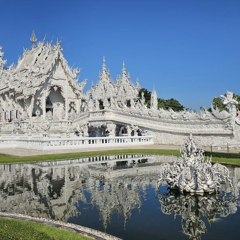 Templo Blanco de Chiang Rai reflejado en el agua